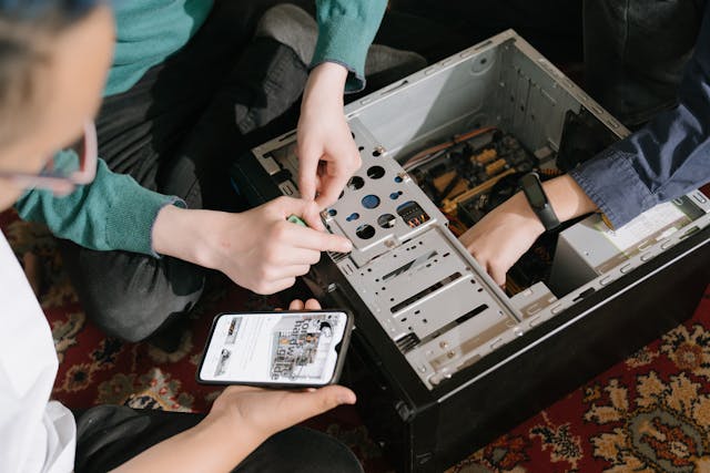 Een vrijwilliger repareert een kapotte computer in een repair café