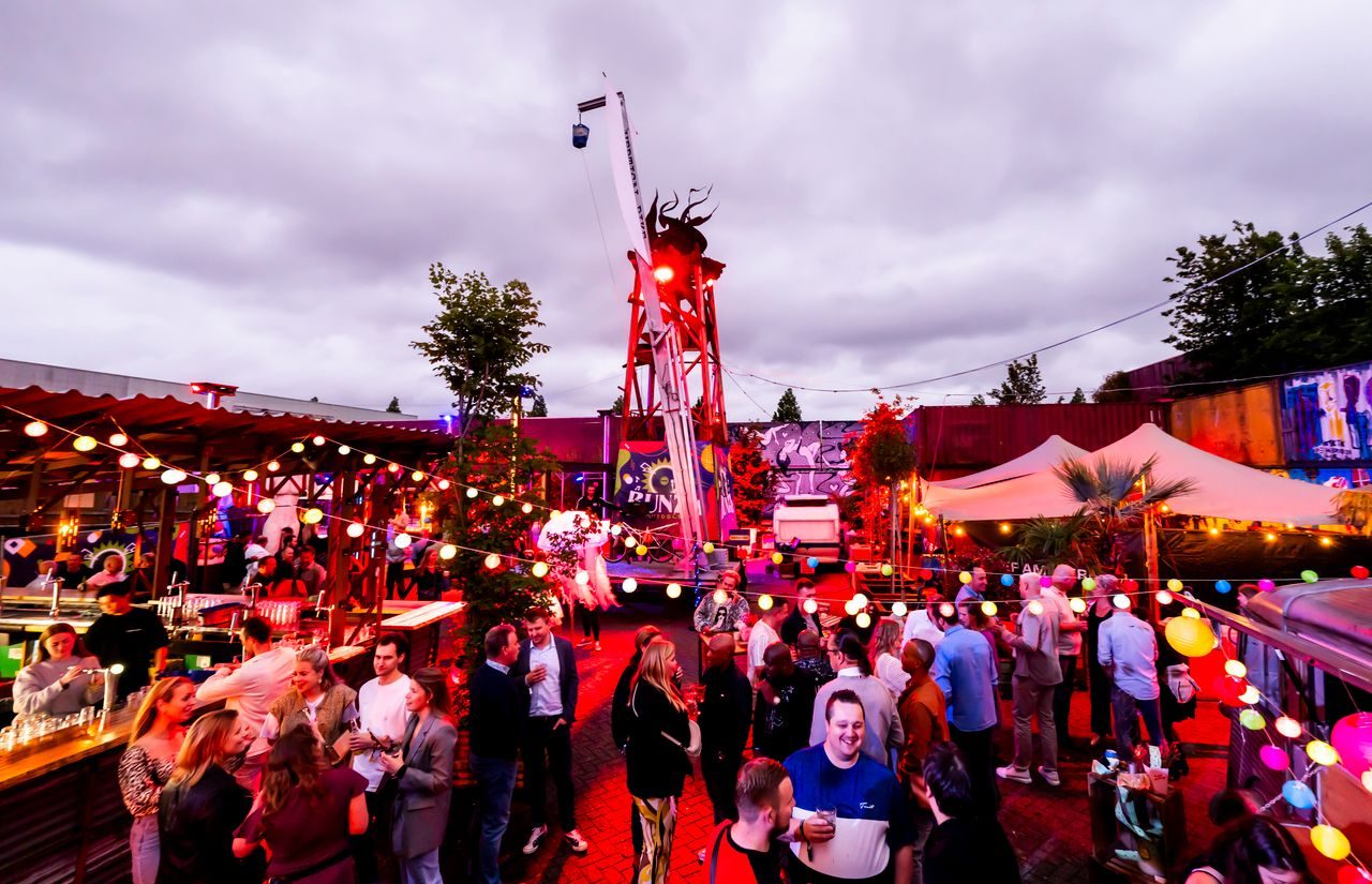 Druk bezocht personeelsfeest in festivalsetting met sfeerverlichting
